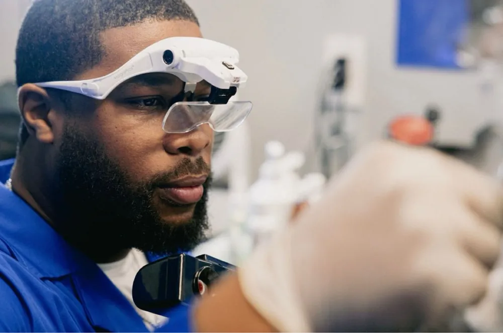 Yisrael Wright wearing magnification loupes during a professional neckline treatment session